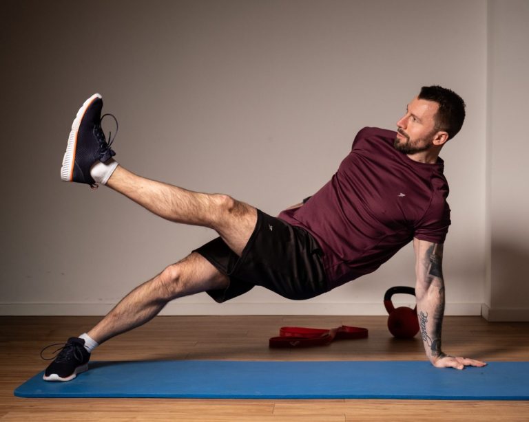 Mann in Sportbekleidung beim Ausüben einer Fitness-Körpergewichtsübung Mann in Sportbekleidung beim Ausüben einer Fitness-Körpergewichtsübung